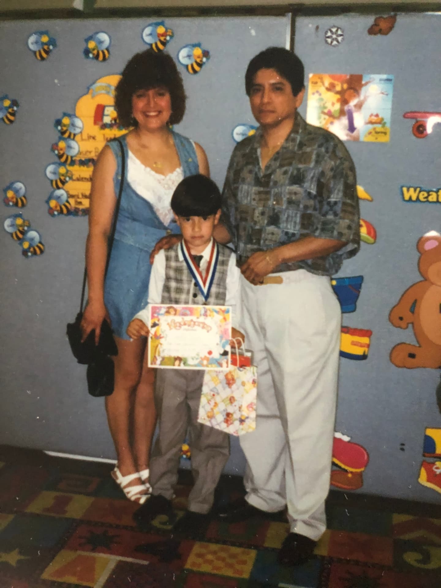 Jonathan as a child at his kindergarten graduation, standing between his parents