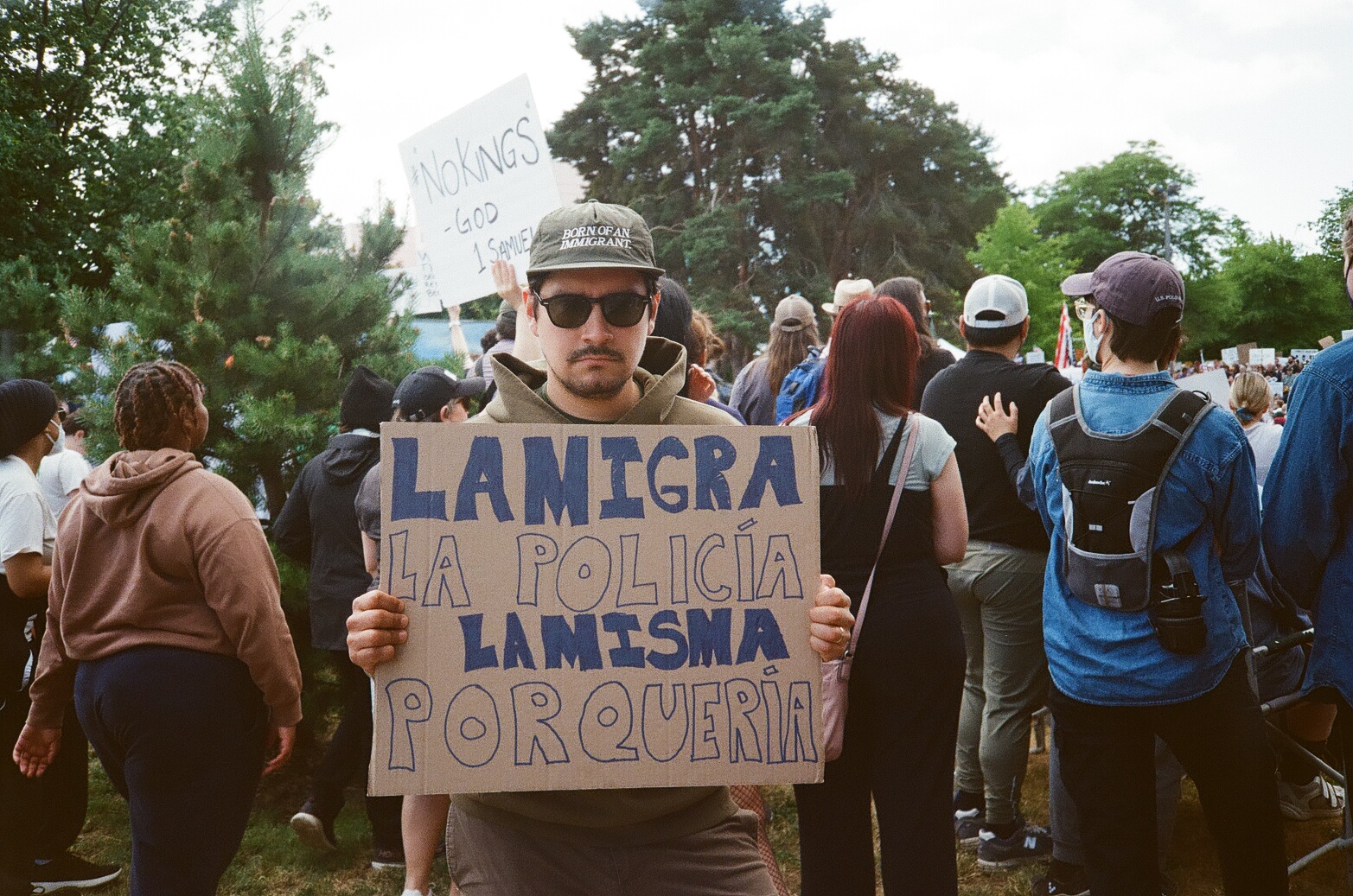 Holding a hand-lettered cardboard sign at a protest march