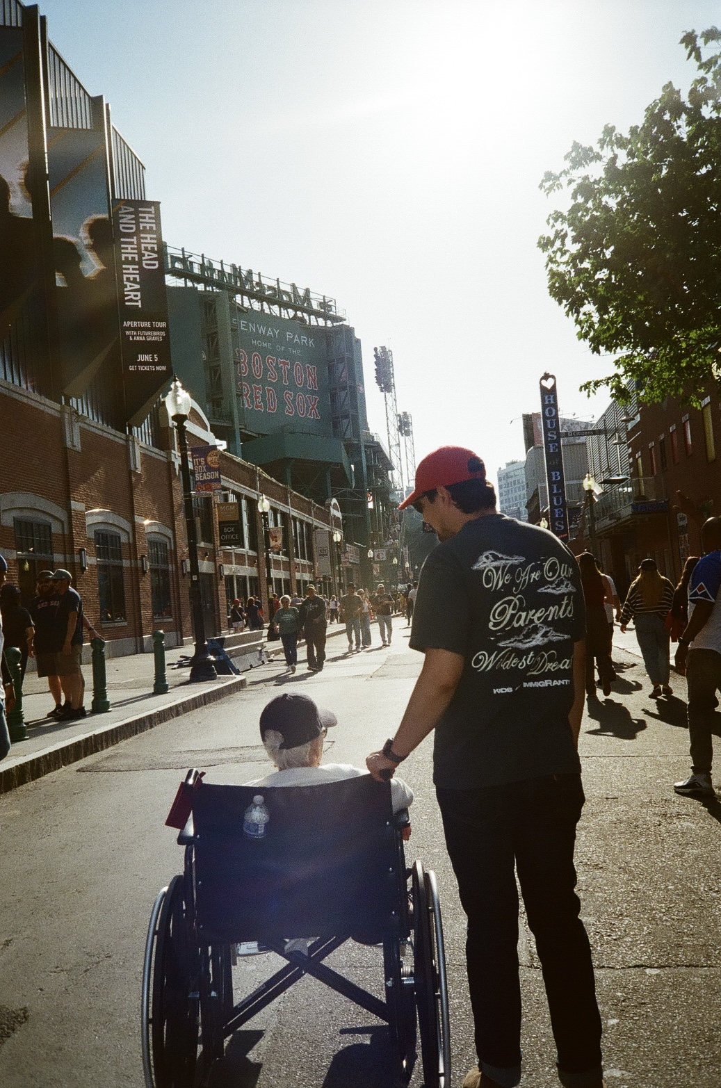 Pushing a family member in a wheelchair outside Fenway Park in Boston
