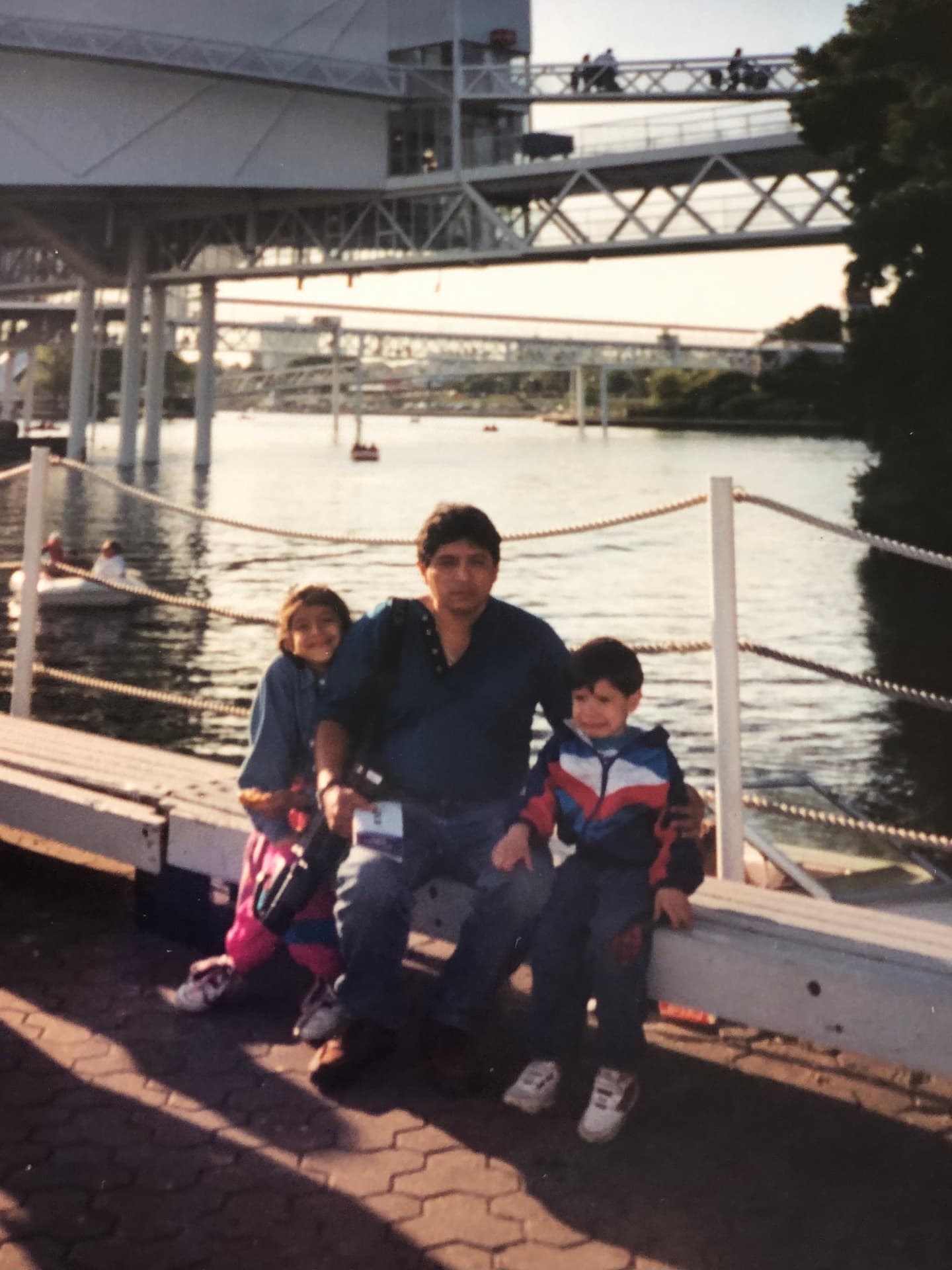 Dad with two kids on a riverfront dock in the 1990s